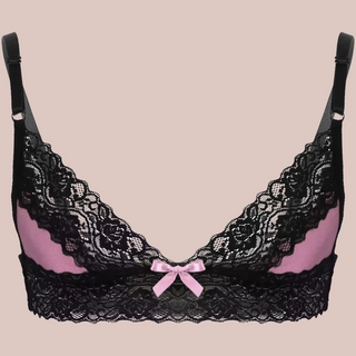 Sized for men to wear, this is a pale pink bralette that has pale pink cups with black lace edging to the top of the cup and a band of black lace that runs from front to back at the bottom of the bra. It has two adjustable thin black straps.