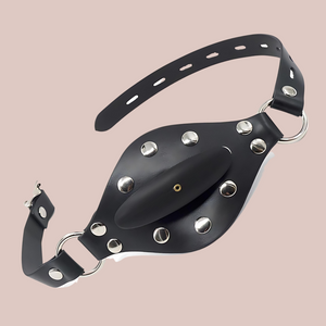 The exterior view of the inflatable ball gag. You can see the black adjustable strap and the front pin hole to inflate the gag.