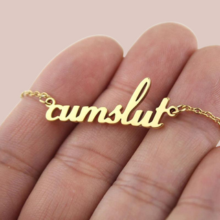 A close up image of the cumslut necklace and its gold chain