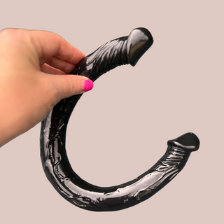 An alternative view of the black double ended dildo, the hand gives an idea of size.