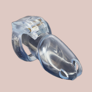 Shown is the clear maxi cock cage that we offer in our version of the Holy Trainer range. It is shown from the side angle so that you have a full view of the assembled chastity cage, the cock cage is shown attached to a base ring and the integral lock is in place, showing how it fits to the body. This product is the clear version, these cages also come in pink and black.