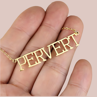 The gold Pervert necklace is shown being held to provide an idea of size.