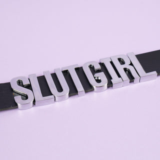 A close up of the silver lettering on the Slut Girl collar