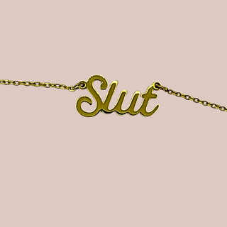 A close up of the gold Slut necklace