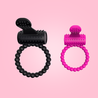 A front view of a black and pink cock ring, from this angle you can see the beading and textured body and tongue.